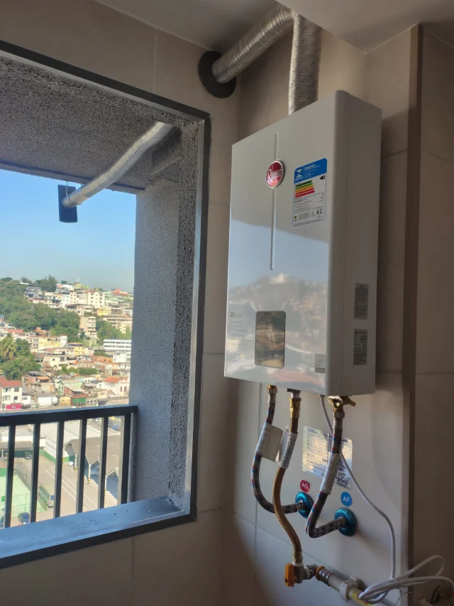Aquecedor a gás digital instalado pela Configás na área de serviço de um apartamento, com chaminé saindo pela janela