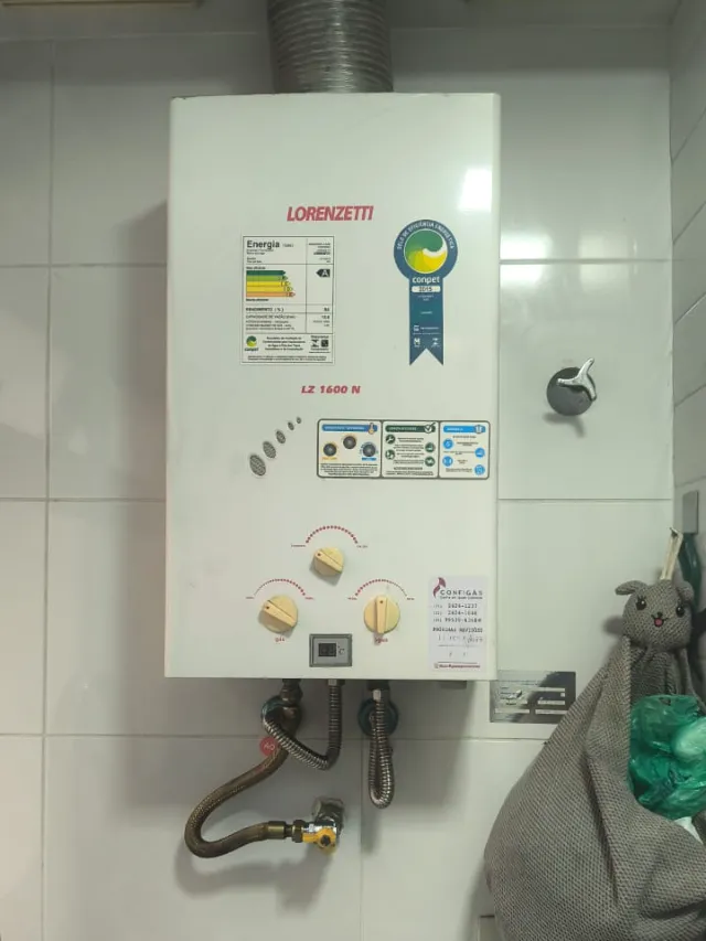 Aquecedor a gás Lorenzetti LZ 1600N instalado em área de serviço, com etiqueta de revisão da Configás