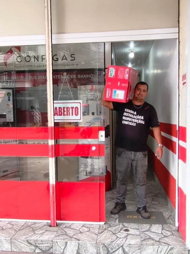 Técnico da Configás na porta da loja segurando a caixa de um aquecedor Lorenzetti